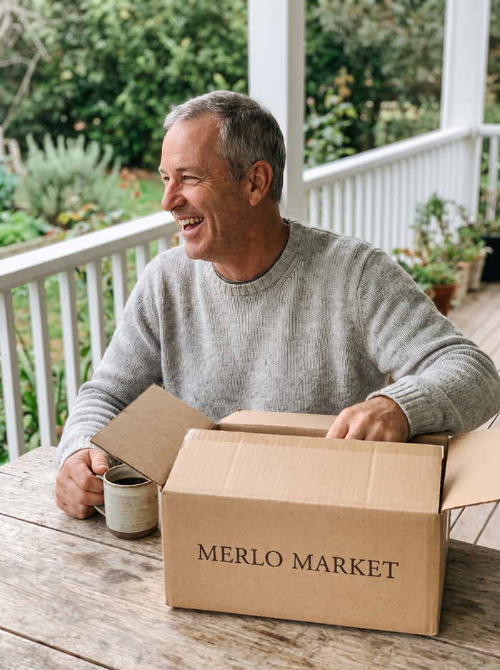 Man opening his Merlo Market delivery on the porch